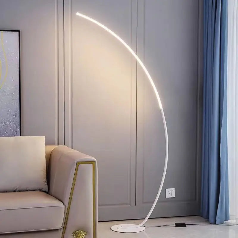 Modern floor lamp with curved design in a living room setting.