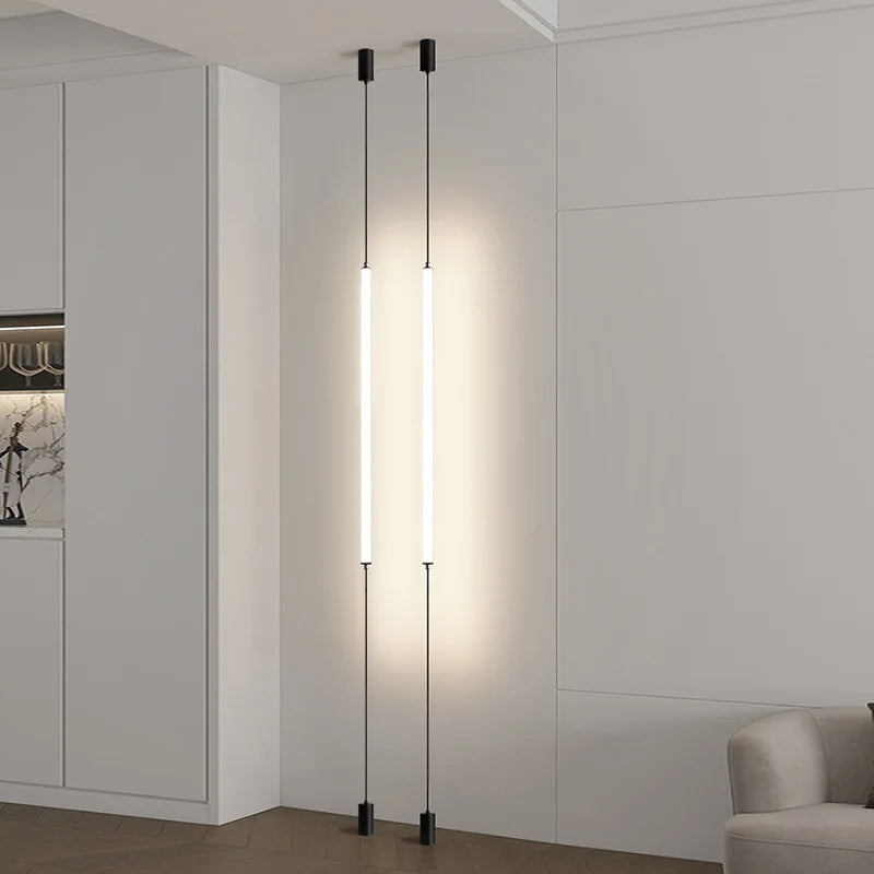 Minimalist vertical LED floor lamps installed from ceiling to floor in a modern interior