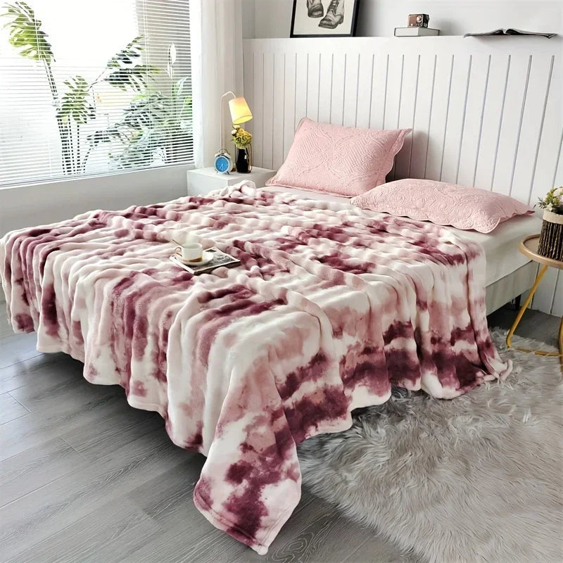 Pink tie-dye blanket on a bed in a bedroom setting with decor elements.