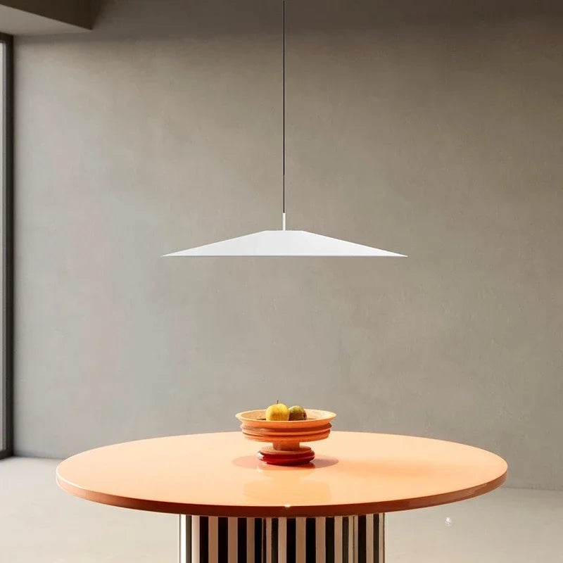 White low-profile pendant light centred over an orange round table