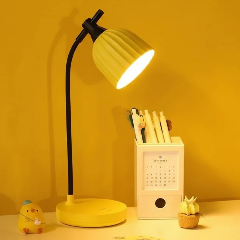 Yellow desk lamp with a pen holder and calendar on a yellow background