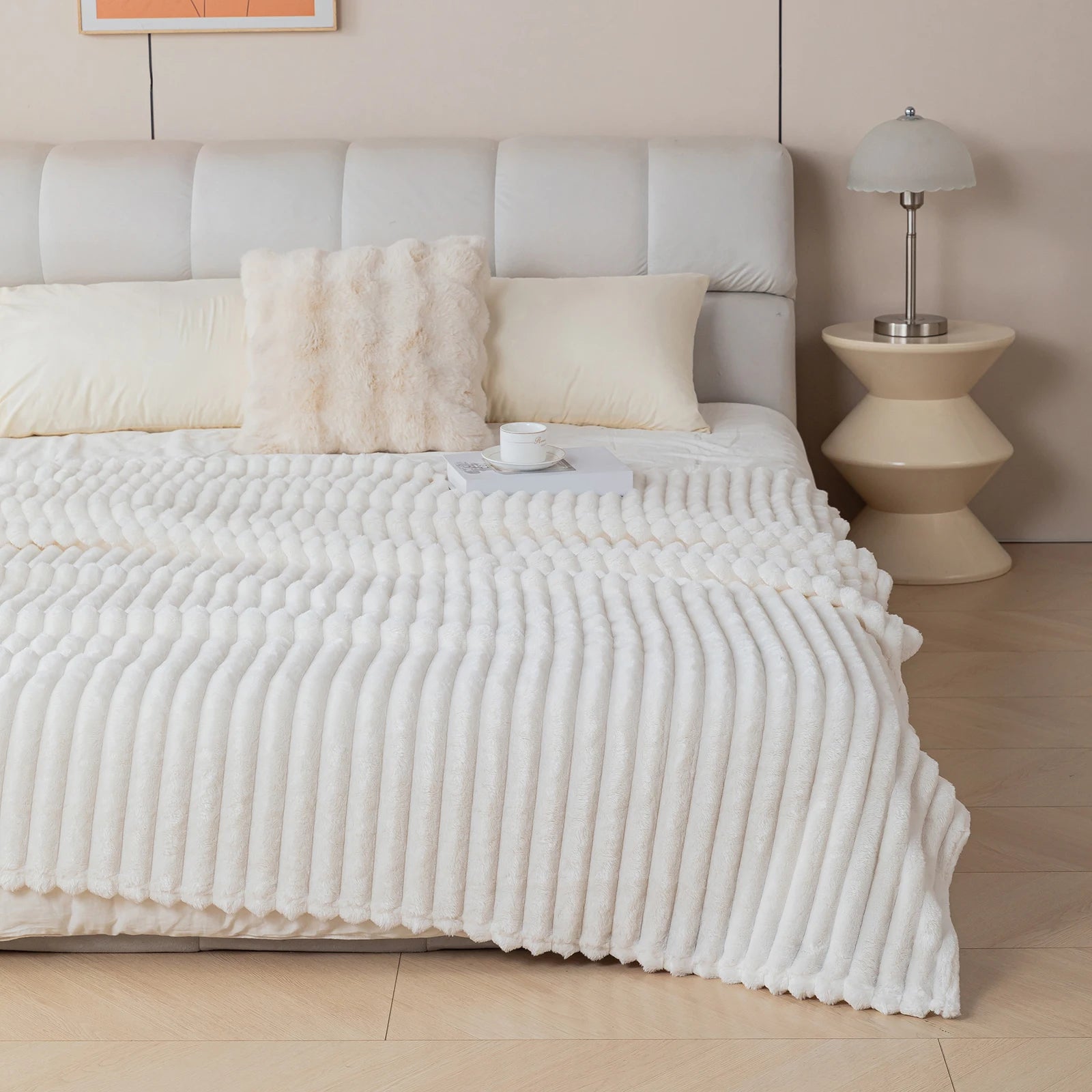 Soft white flannel blanket with fluffy texture layered on a bed