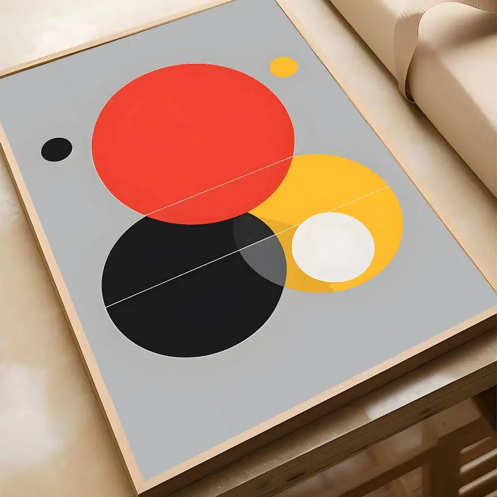 Bold abstract canvas print with overlapping red, yellow, black, and white circles on a grey background, in a natural wood frame.