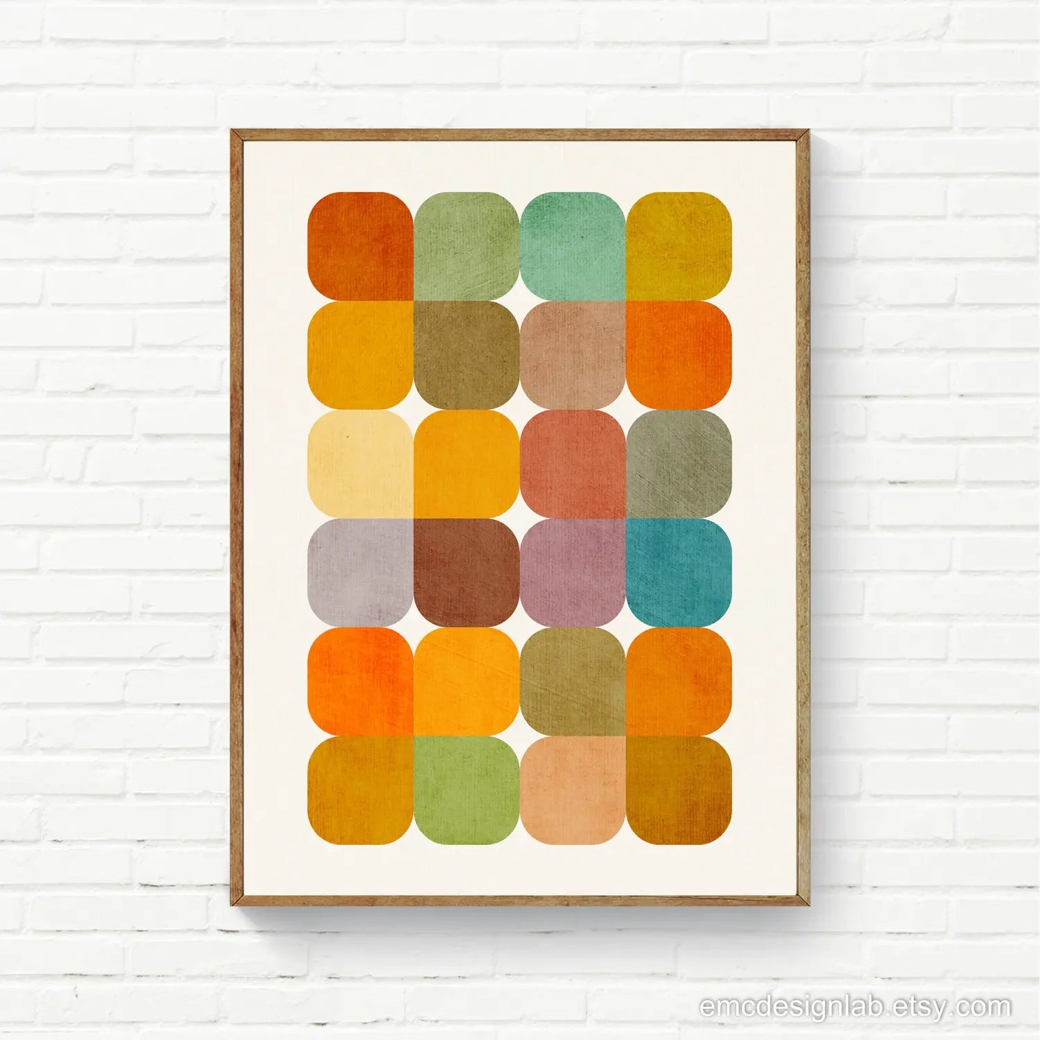 Framed abstract art print with colorful squares on a white brick wall