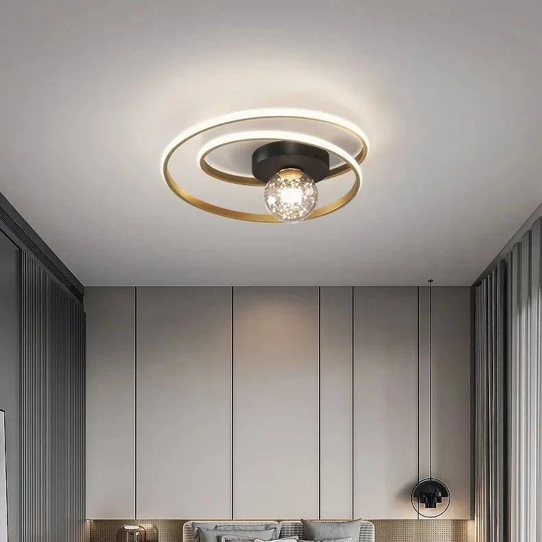 Close-up of black double-spiral LED ceiling light with textured amber glass globe against a white ceiling