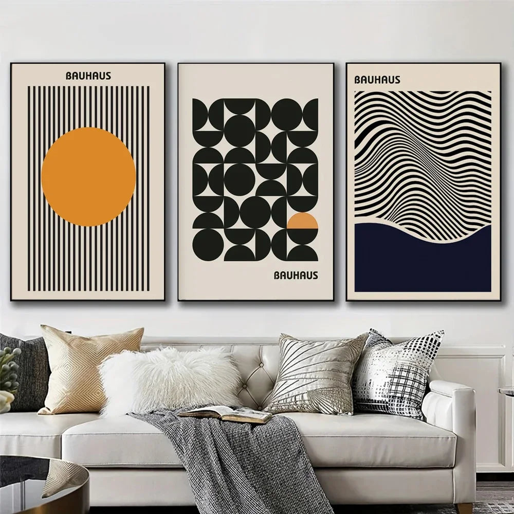 Three Bauhaus-style posters on a wall above a sofa with decorative pillows.
