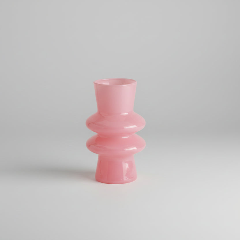 Pink vase with dimensions labeled on a white surface