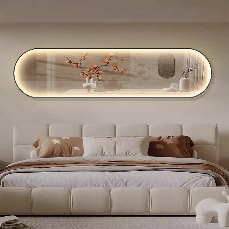 Oval-shaped LED wall art displaying a minimalist scene of a branch with orange persimmons and small white birds against a warm beige background, mounted above a contemporary beige sofa.