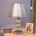 table lamp with a modern silver tapered perforated metal shade.