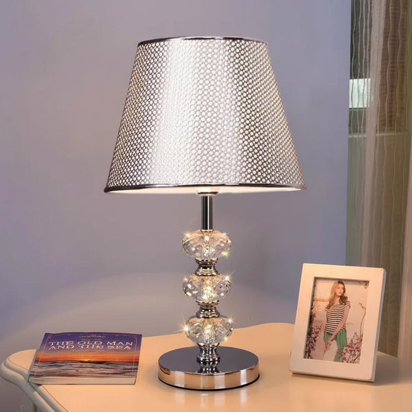 table lamp with a modern silver tapered perforated metal shade.