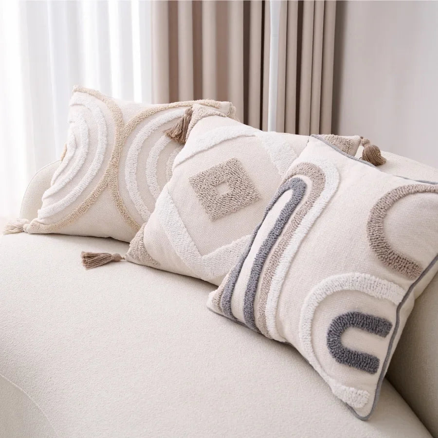 Decorative pillows with geometric patterns on a light-colored sofa.
