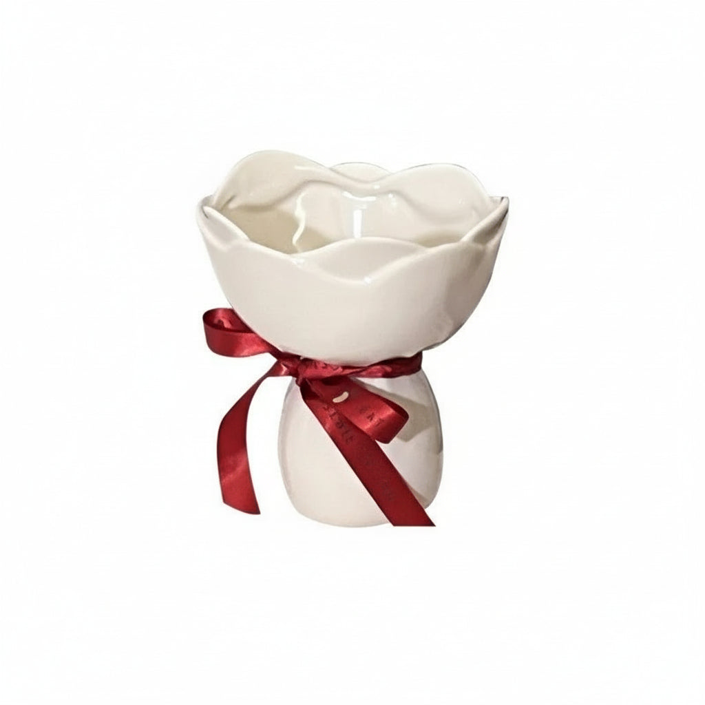 White ceramic rose-shaped vase with a red ribbon.