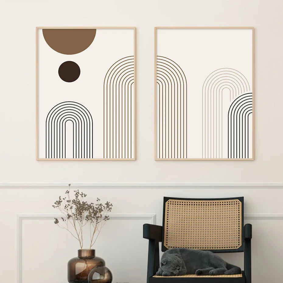 Two abstract art pieces on a wall with a chair and vase in the foreground.
