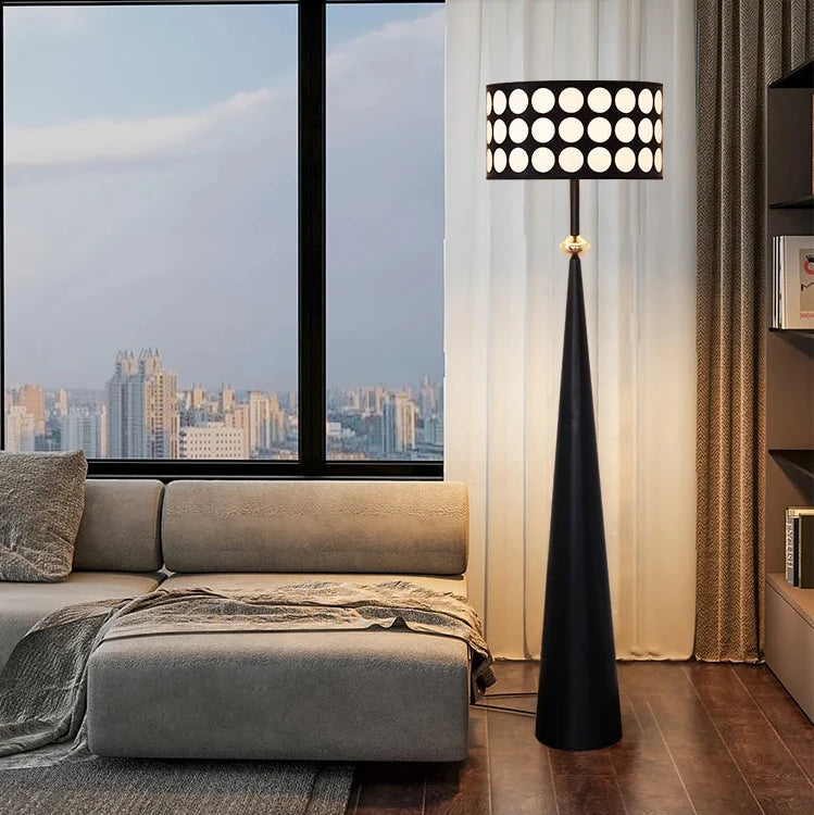 Modern living room with a gray sofa, black floor lamp, and cityscape view.