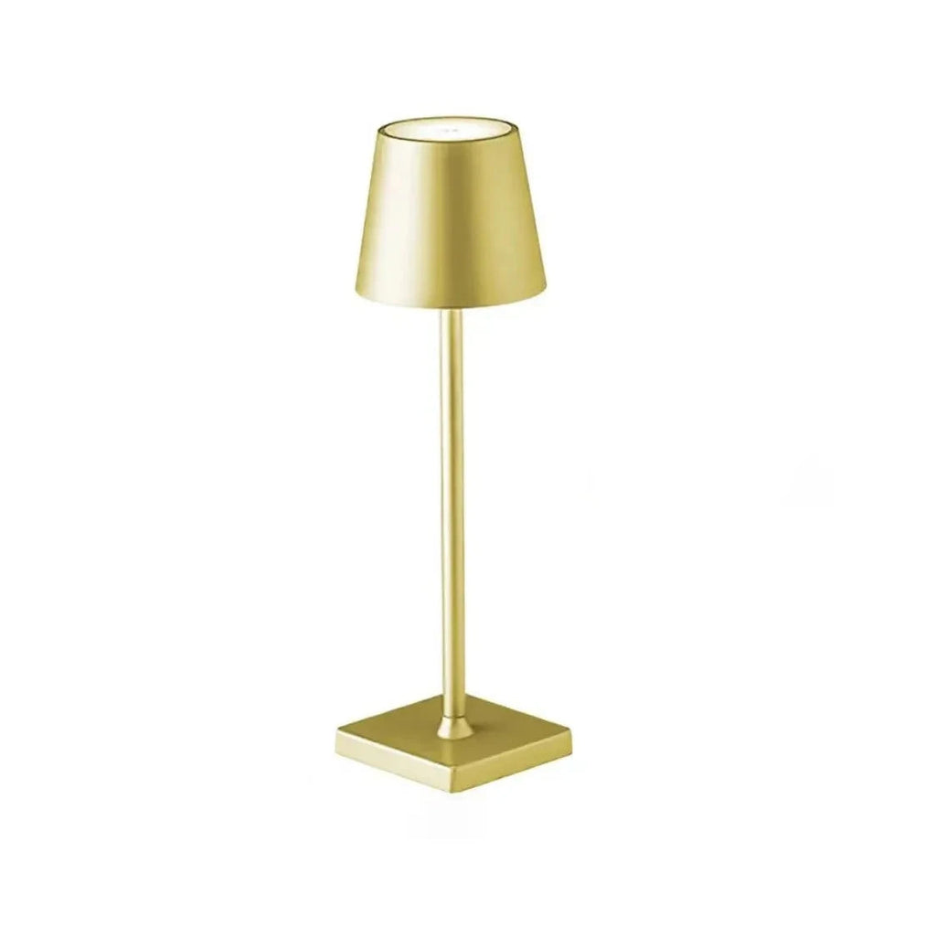 A gold table lamp on a white background.