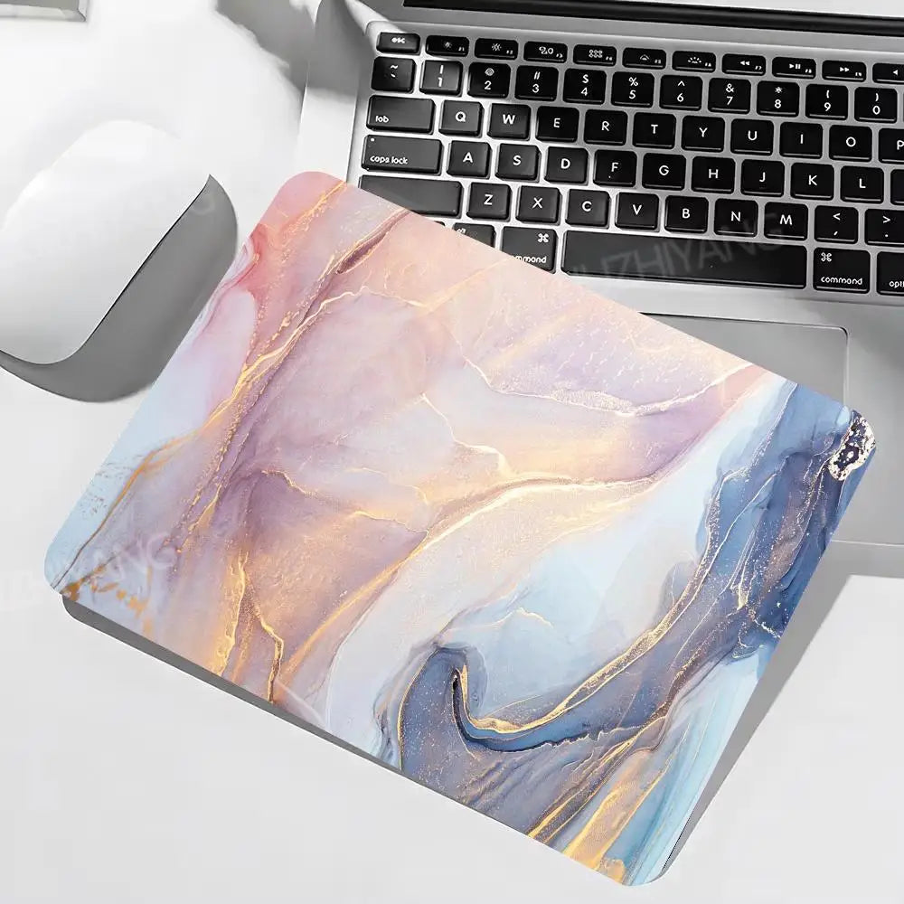 Marble-patterned mouse pad on a desk with a laptop and mouse.