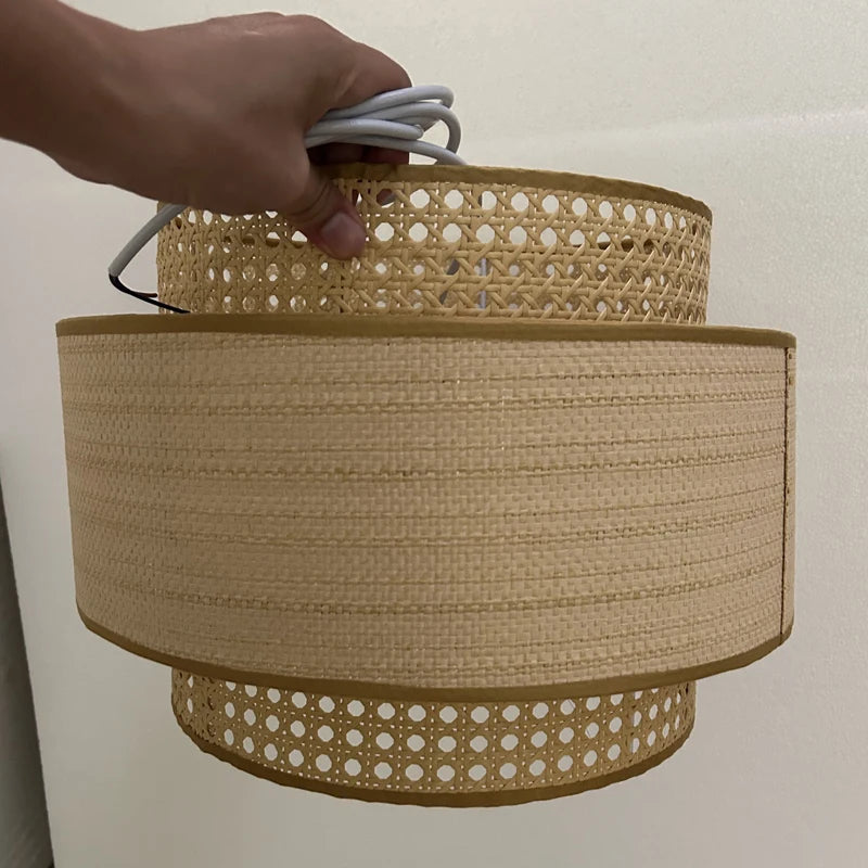 Hand holding a woven lampshade with a plain background