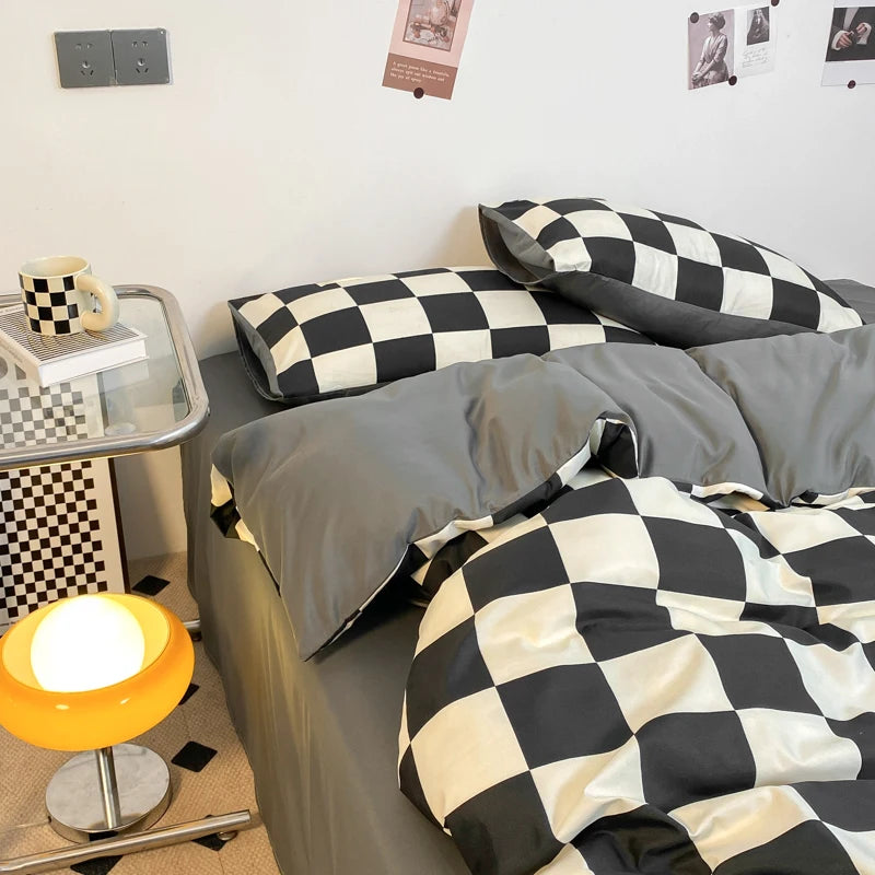 Black and white checkerboard duvet cover set with matching pillowcases dressed on a double bed in a modern styled bedroom