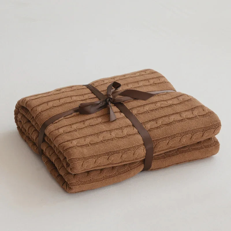 Stack of brown textured towels tied with a ribbon on a light background