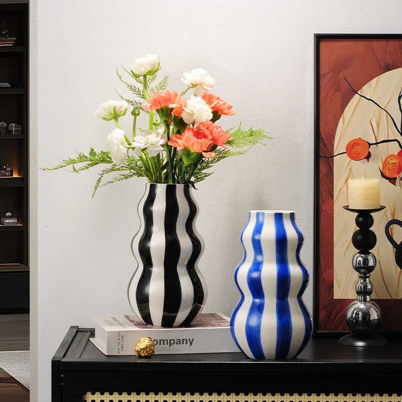 Two vertical wave pattern vases, black & white, and blue and white
