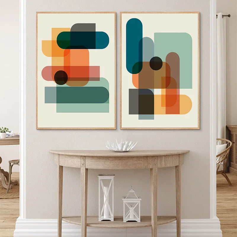 Two abstract art pieces on a wall above a wooden console table.