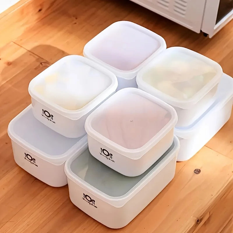 Set of white food storage containers with lids on a wooden floor