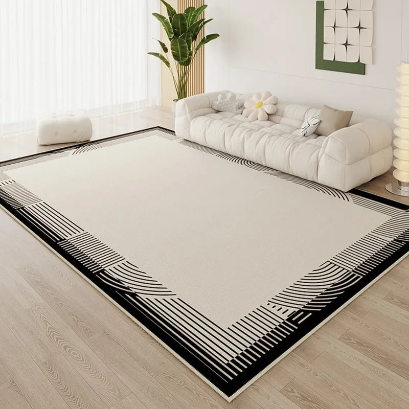 Large cream area rug with bold black arc stripe border in a bright minimalist living room with white cloud sofa