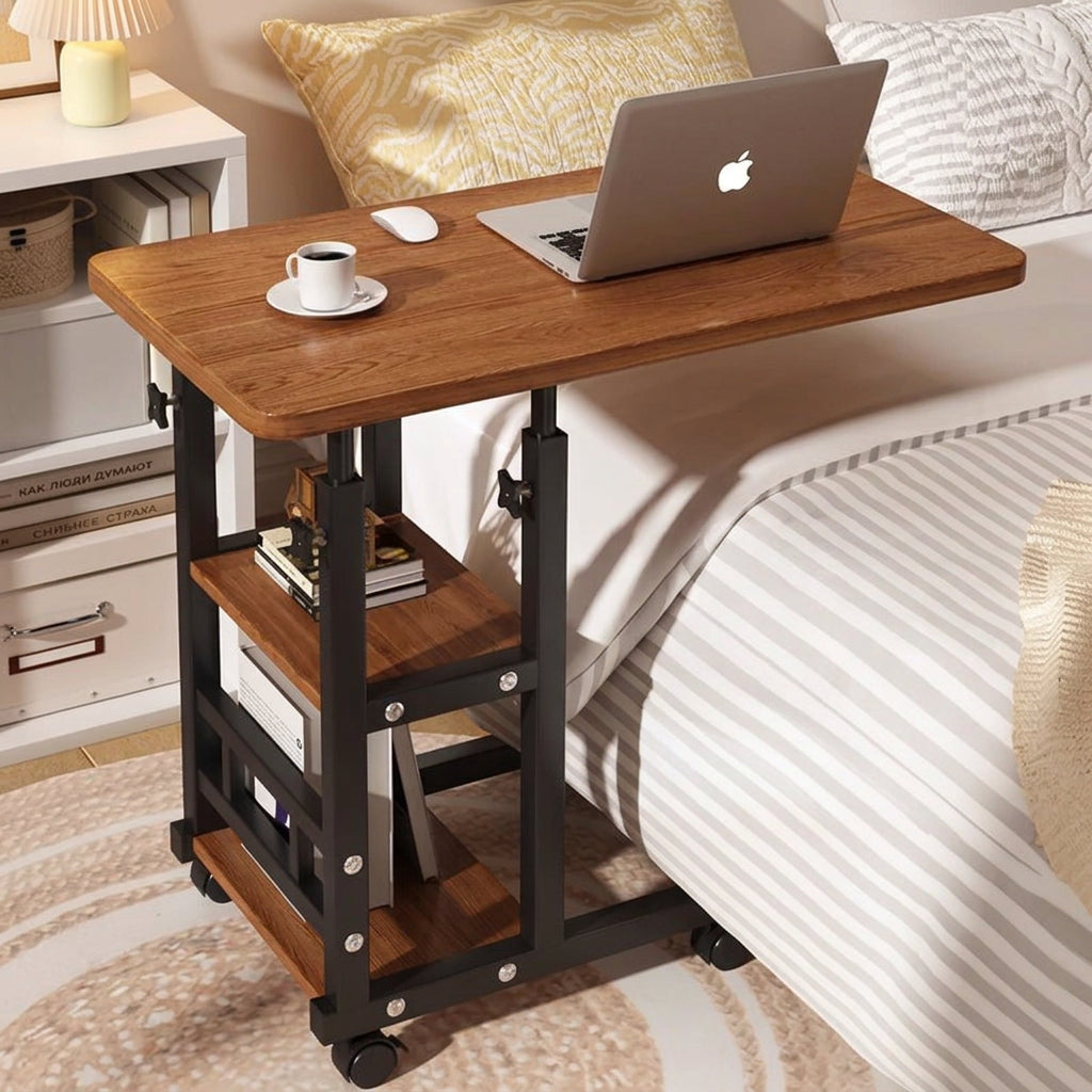Wooden desk with laptop and coffee cup on a bed.