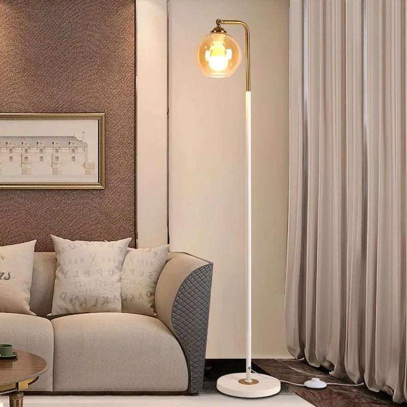 White stem brass globe floor lamp styled next to the sofa in the living room
