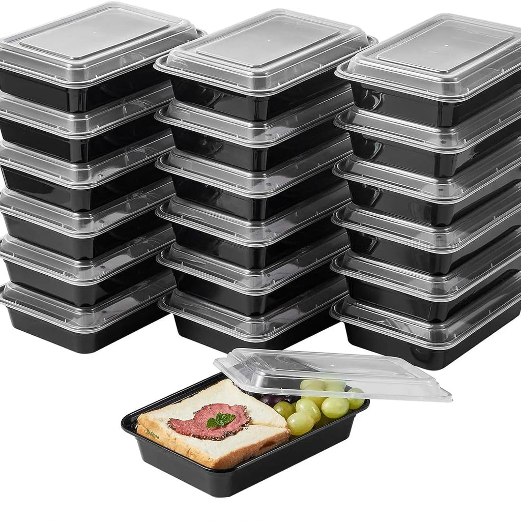 Multiple black meal prep containers with clear lids on a white background.