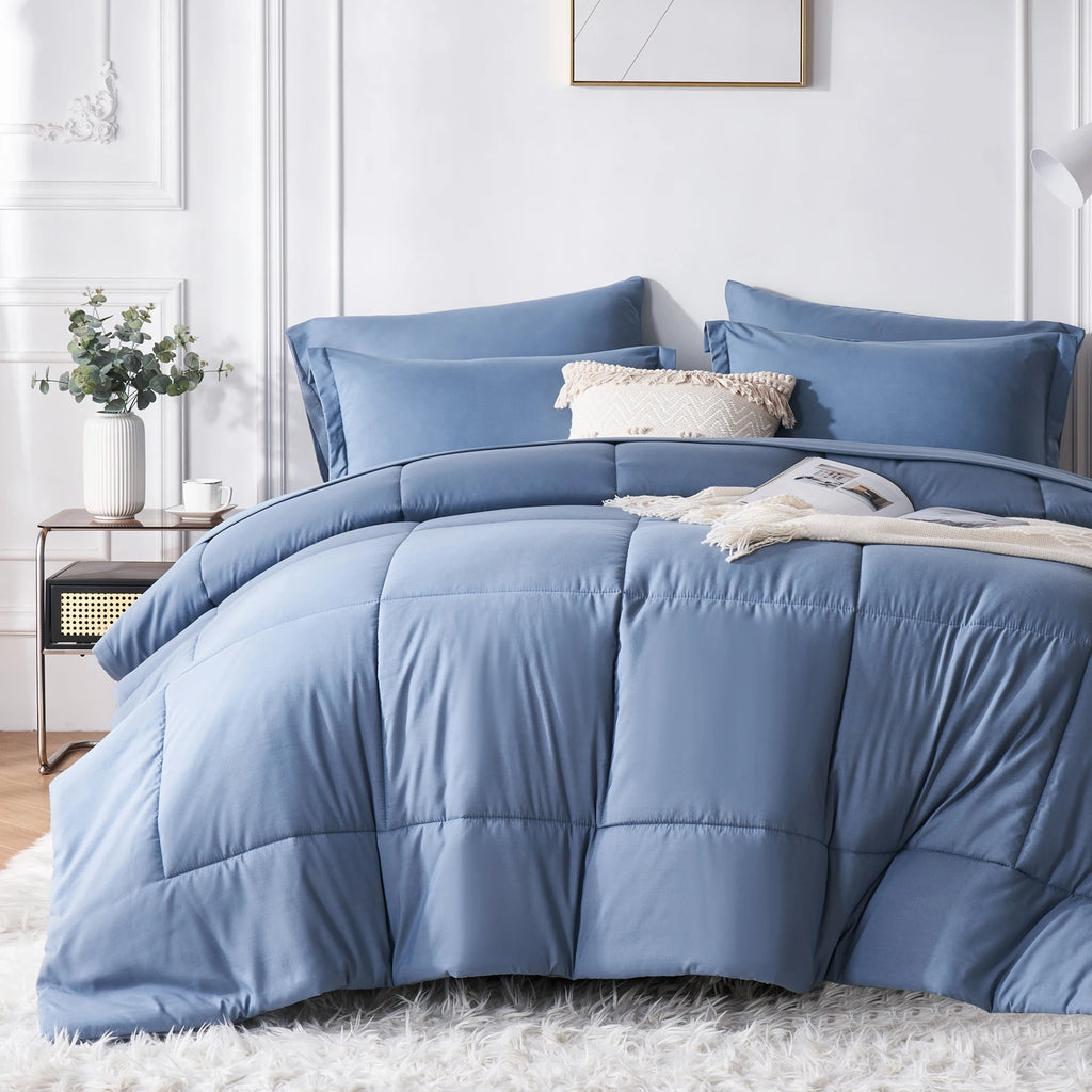 Blue comforter set on a bed in a bedroom with decorative elements.