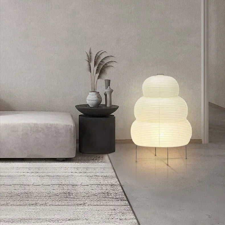 Modern interior with a textured rug, grey sofa, and a unique Japanese rice paper lamp on a side table.