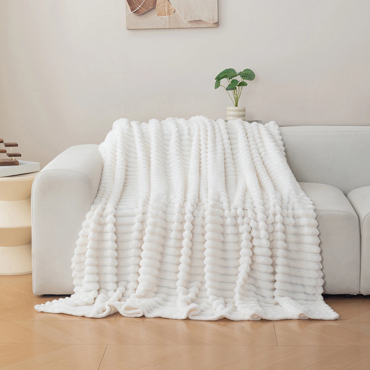 White textured blanket draped over a sofa in a living room setting.