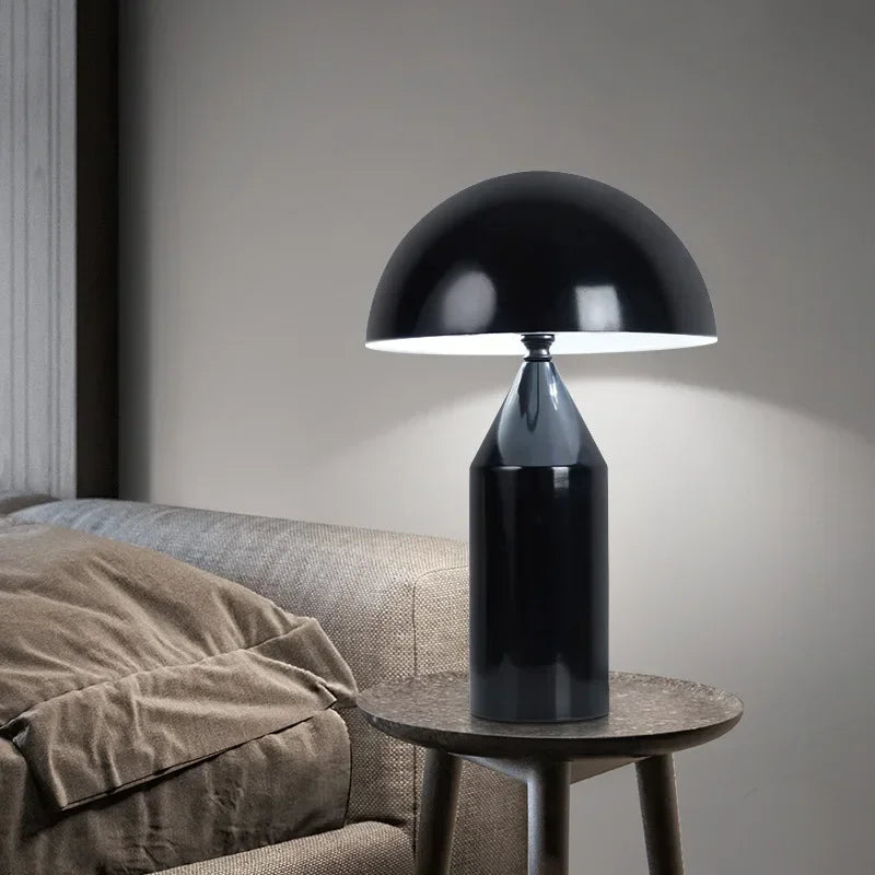 Black table lamp on a wooden side table next to a sofa.
