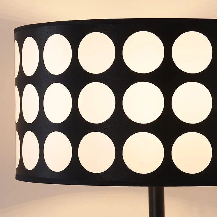 Close-up of black and white polka dot PVC drum lampshade illuminated from within