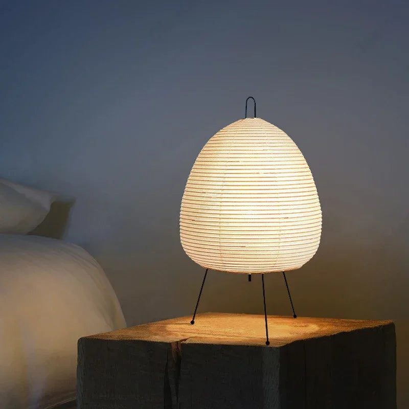 Japanese table lamp on a wooden surface with a soft glow against a neutral background