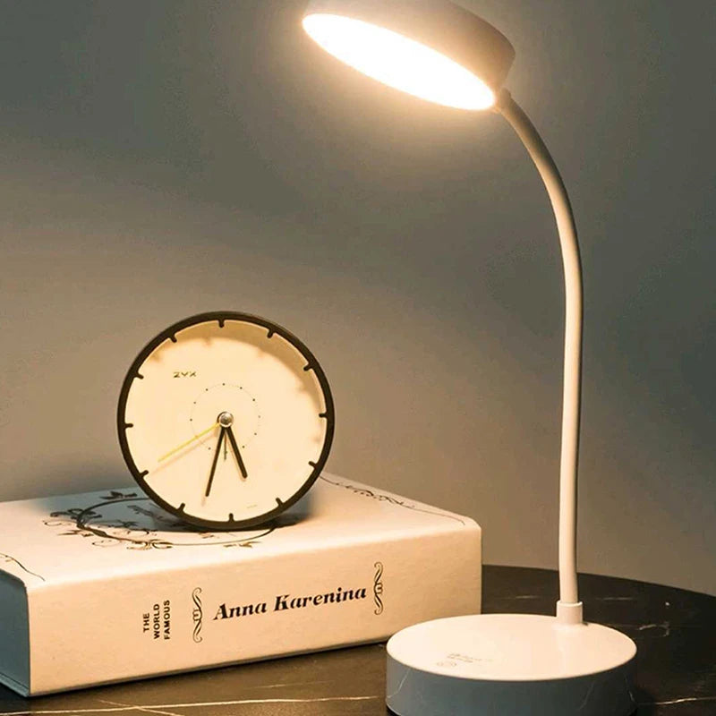 Desk lamp and clock on a book with a dark background