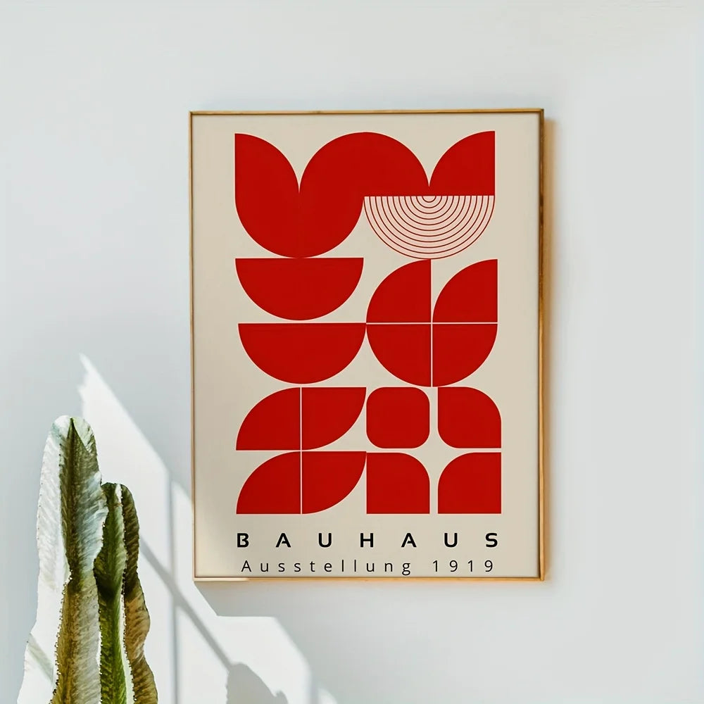 Framed Bauhaus poster with red geometric design on a light gray wall.