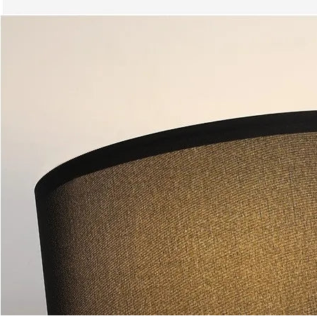 Close-up of a black linen lampshade on a stainless steel floor lamp