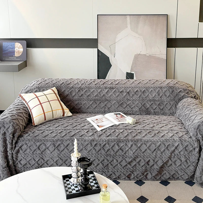 Gray textured sofa cover on a sofa with decorative pillows and a coffee table in a modern living room.