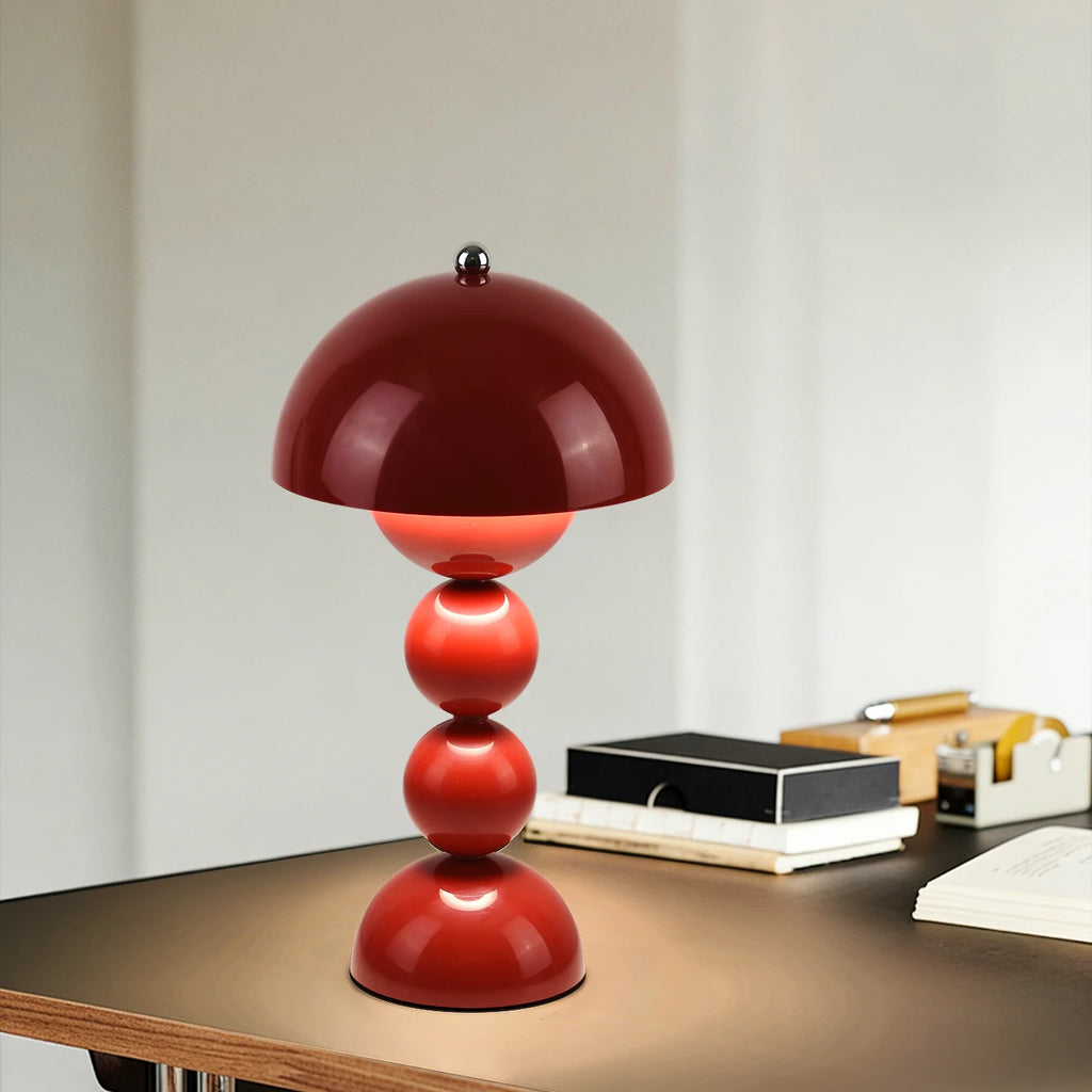 Red table lamp on a wooden surface with a neutral background