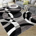 Black, grey, and white Nordic geometric rug with bold circle and arc pattern.