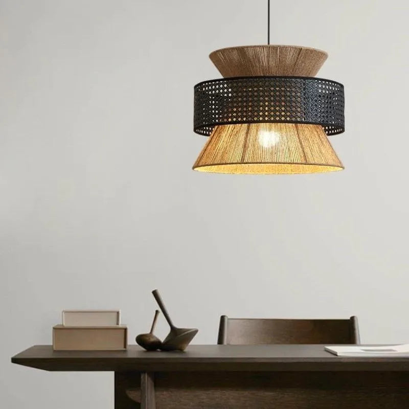 Modern pendant light with woven design hanging above a wooden table.