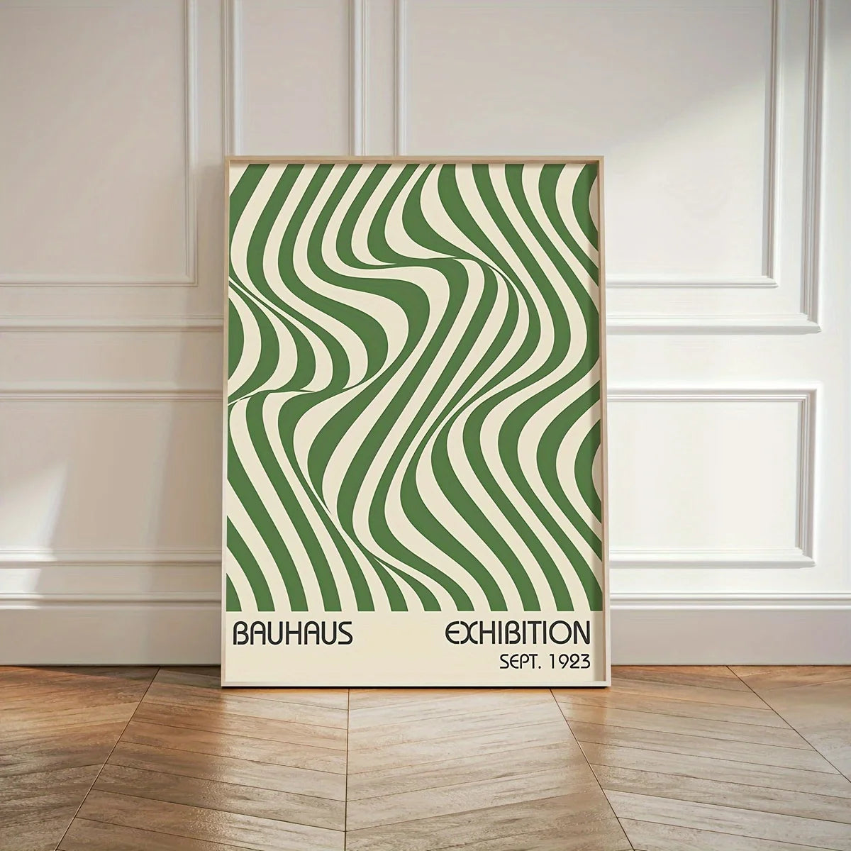 Framed Bauhaus exhibition poster with green and white wavy pattern on a wooden floor.
