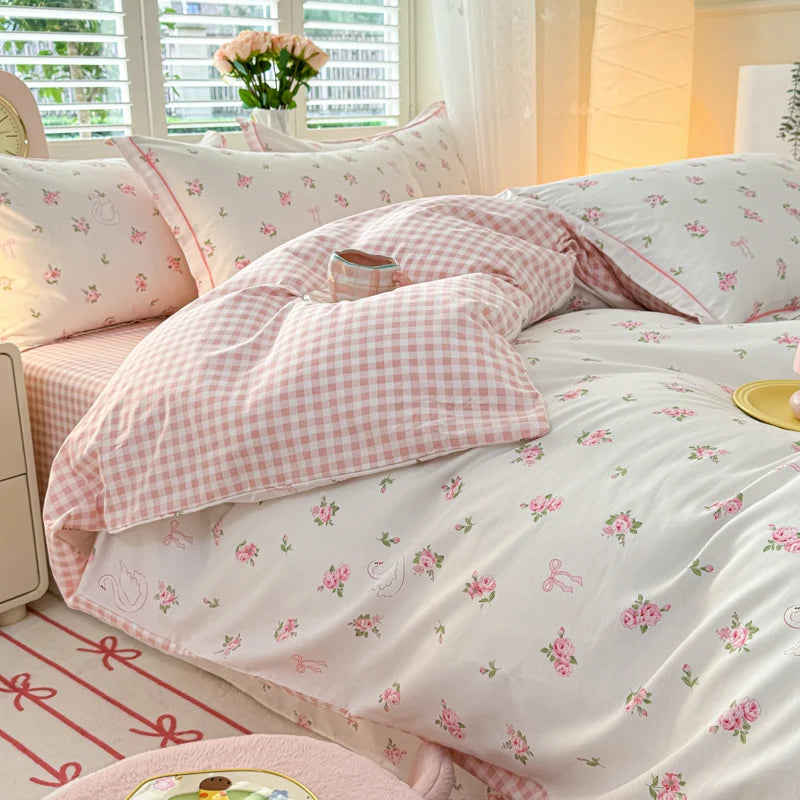 Dainty Sprig floral bedding featuring small pink rosebuds on white cotton with a pink gingham underside.
