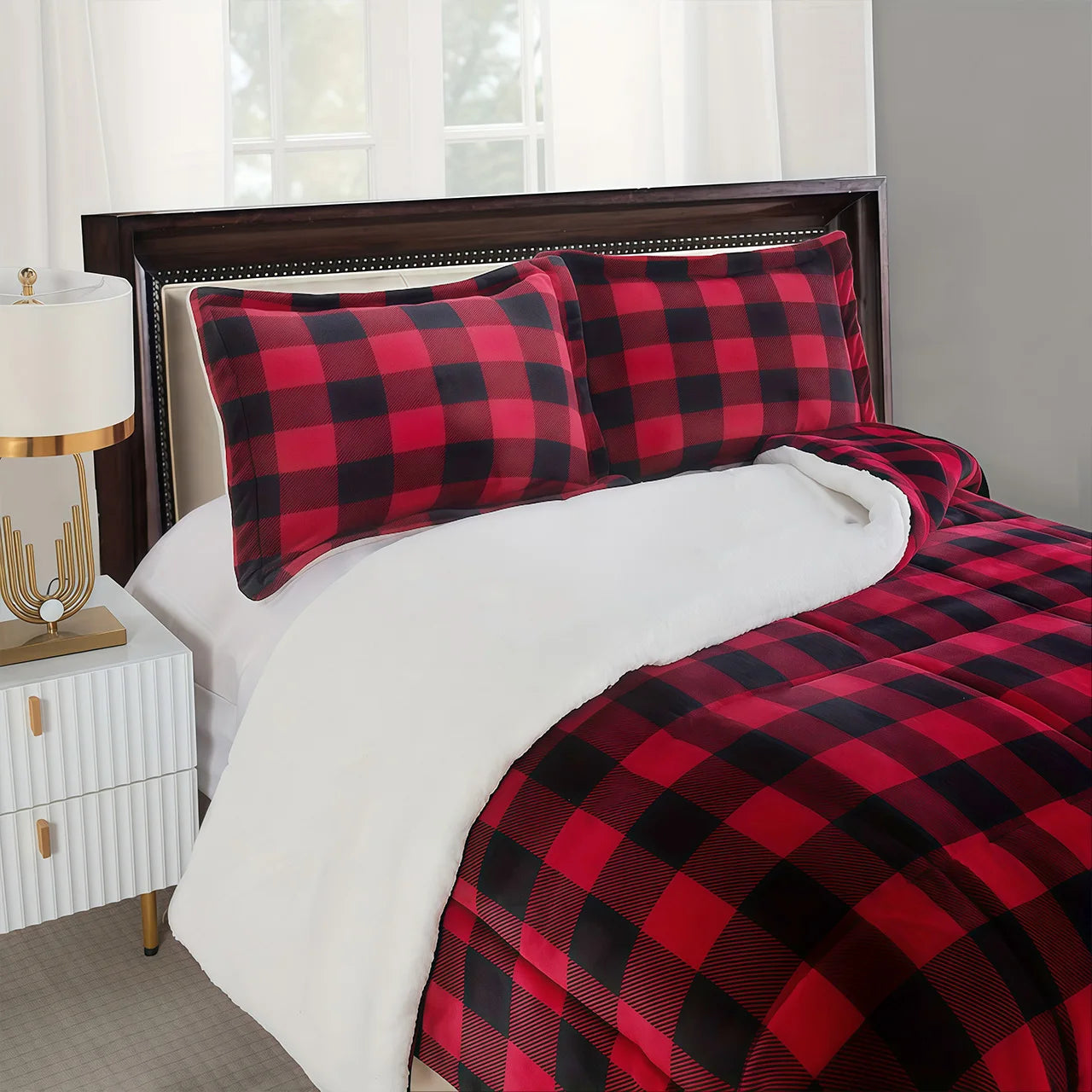Red and black checkered bedding set on a bed with white sheets.