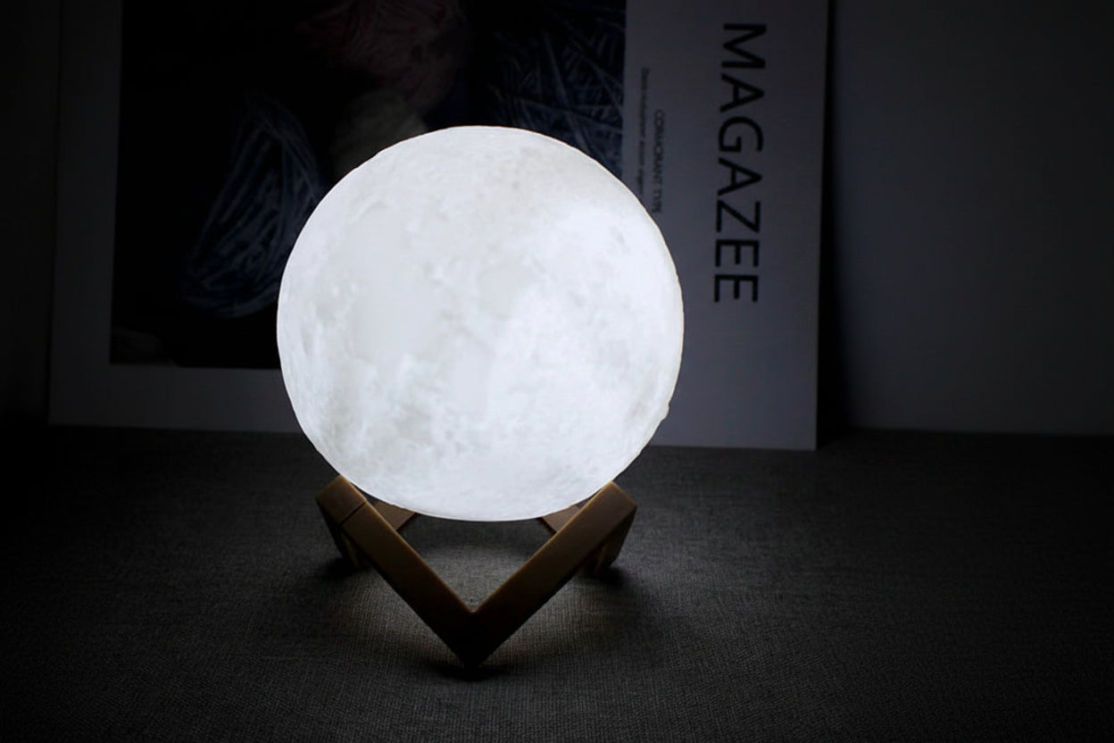 Moon-shaped night light emitting white light on a dark background