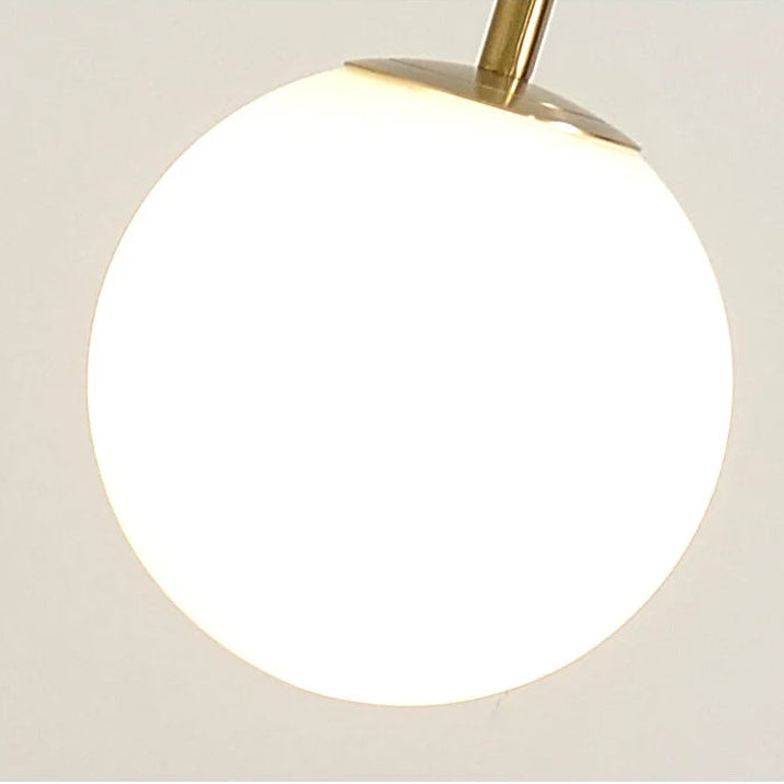 Modern globe light fixture with glass shade on a neutral background