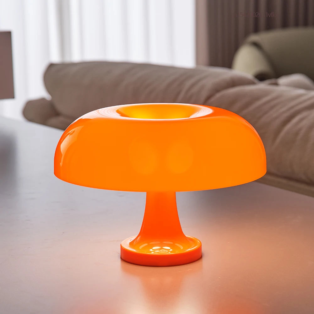Orange table lamp on a reflective surface with a blurred background