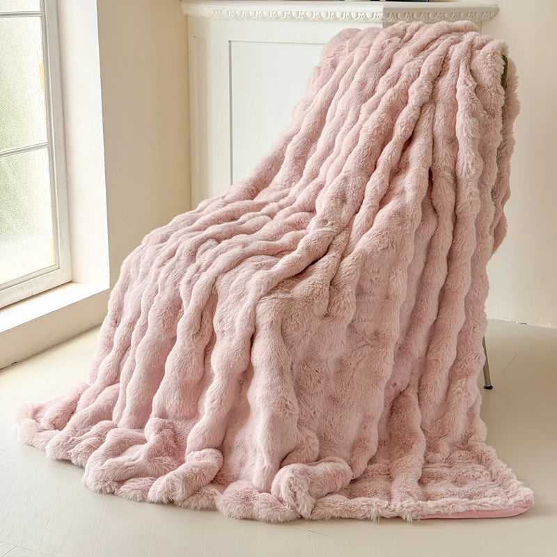 Pink fluffy blanket on a light-colored floor with a window in the background